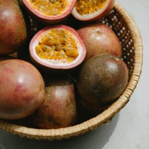 Close-up of ripe passion fruits in a wicker basket on a light background.